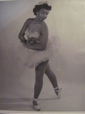 Black and white photo of Sydney King posing in a white costume with a crown